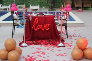 Ein Tisch mit einem Schild mit der Aufschrift „Liebe“ neben einem Pool in der Unterkunft KURTI Hotel in Golem + 68 Fotos