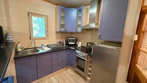 a kitchen with blue cabinets and a sink at Chata U malého Janka in Bojnice