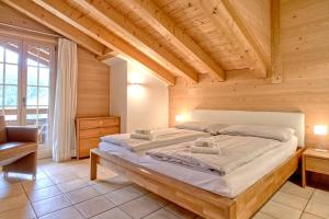a bedroom with a large bed in a wooden room at Apartment Brunnen - GRIWA RENT AG in Grindelwald