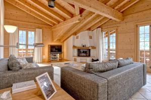 a living room with two couches and a fireplace at Apartment Brunnen - GRIWA RENT AG in Grindelwald