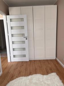 an empty room with white doors and a rug at Royal Apartment in Rumia