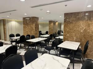 a restaurant with tables and chairs and marble walls at Ritaj Al-Tala'i in Mecca