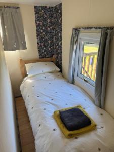 a small bed in a room with a window at Lodge 18 - Caer Beris Park - No Tradesmen in Builth Wells
