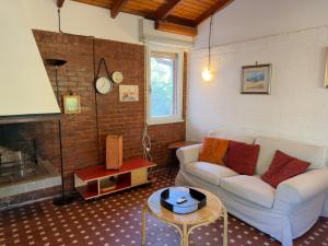 a living room with a couch and a table at Villa Tamerici - Garden & Parking in Lignano Sabbiadoro