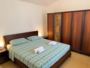 a bedroom with a bed with two towels on it at Villa Tamerici - Garden & Parking in Lignano Sabbiadoro