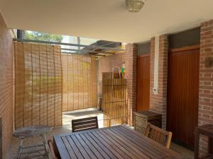 a patio with a wooden table and a brick wall at Villa Tamerici - Garden & Parking in Lignano Sabbiadoro +26 photos