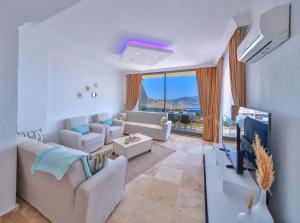 a living room with white furniture and a large window at Apollon Apartment in Kalkan