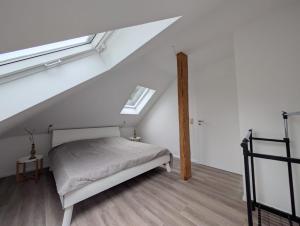 a attic bedroom with a bed and a window at NEU - Nette kleine Unterkunft in Heide - Mit Gutscheinen für Bistro und Minigolf in Heide