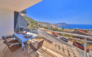 a balcony with a table and chairs and the ocean at Apollon Apartment in Kalkan