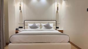 a bedroom with a bed with white sheets and pillows at hotel midas in Sāgar