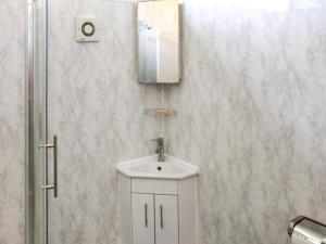 a bathroom with a white sink and a mirror at Noddfa in Newcastle Emlyn +5 photos