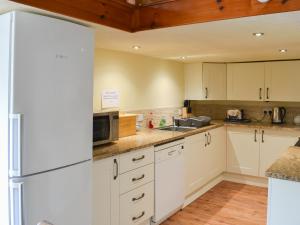 a kitchen with white cabinets and a refrigerator at Fennel in Kelly