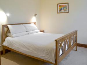 a bedroom with a bed with white sheets and pillows at Elderberry House in Kelly