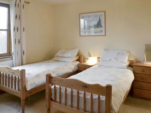 two twin beds in a bedroom with a dresser at Elderberry House in Kelly