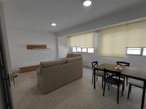 a living room with a couch and a table and chairs at Pedra Pateira 1 in Ribeira