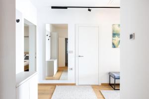 a hallway with white walls and a door with a rug at LUX Dolce Vista Apartment - Portorož in Portorož +110 photos