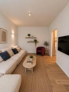 a living room with a white couch and a coffee table at Maison Bruxelles in Brussels
