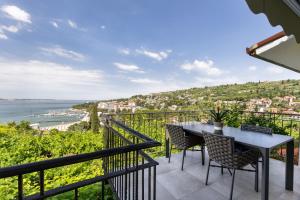a balcony with a table and chairs and the ocean at LUX Dolce Vista Apartment - Portorož in Portorož