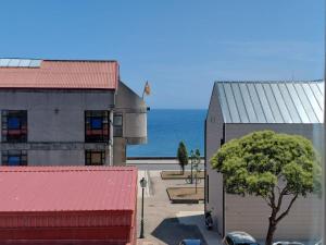a building with a tree in front of the ocean at Pedra Pateira 2 in Ribeira