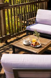 a coffee table with a plate of food on a deck at Le Domaine de La Tour des Vents in Bergerac