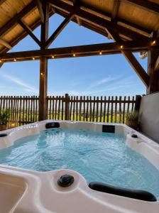 a hot tub in a backyard with a wooden fence at Le Domaine de La Tour des Vents in Bergerac