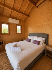 a bedroom with a large bed in a wooden room at Le Domaine de La Tour des Vents in Bergerac