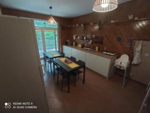 a kitchen with a table and chairs in a room at Biały Dom - Pokoje in Wejsuny