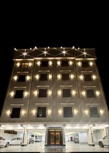 a lit up building with cars parked in front of it at Spacious Two-Bedroom Apartment with a Large Living Room, comfortable and well organized, perfect for a relaxing stay in Jeddah