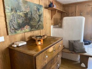 a wooden dresser and a chair in a room at SOMMERFRISCHE TSCHENGLS Ein ganzes historisches Ferienhaus für euch in SÜDTIROL Urlaub im ruhigen Bergdorf Tschengls im Vinschgau mit Weitblick und Gartenterrasse ideal für Kleingruppen Familien mit Hund Besonders empfehlenswert im FRÜHLING und HERBST in Lasa