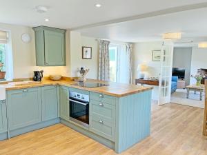 a kitchen with blue cabinets and a counter top at The Dairy - Uk50427 in Malton