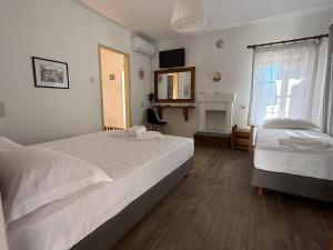 ein Schlafzimmer mit zwei Betten und einem Spiegel in der Unterkunft Tsagarakis Studios in Xinóvrisi