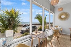 a room with a table and chairs and a large window at Beach Front Guest House in Eastbourne