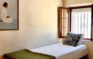 a small bedroom with a bed and a window at Casa Pueblo Lopez in Fuengirola +23 photos