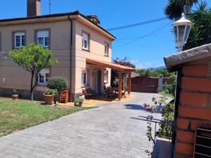 a house with a patio and a driveway at LA BUGANVILLA in Gijón