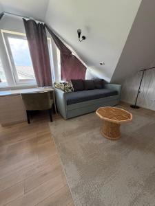 ein Wohnzimmer mit Sofa und Tisch in der Unterkunft Skrablas Boutique Hotel in Rucava