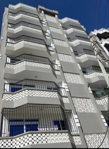 a tall white building with windows on the side of it at Soft stay homes in Mombasa
