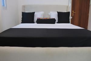 a large bed with black and white sheets and pillows at Soft stay homes in Mombasa