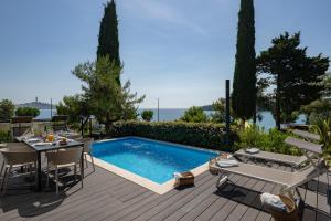 a patio with a table and a swimming pool at Porton Nature Hideouts in Rovinj