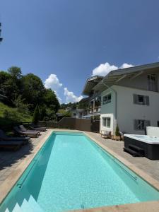 a swimming pool in front of a house at Alpenglühn Apartments - Adult Only in Berchtesgaden