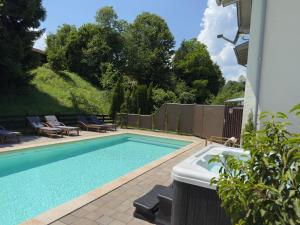 a swimming pool with two lounge chairs at Alpenglühn Apartments - Adult Only in Berchtesgaden