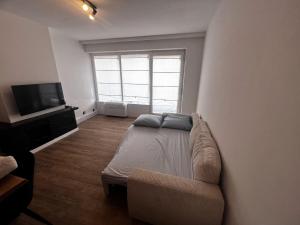 a living room with a bed and a tv at Studi'eau2 in Ostend