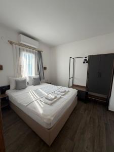 ein Schlafzimmer mit einem Bett mit weißer Bettwäsche und einem Fenster in der Unterkunft Queen Otel in Bodrum City + 26 Fotos