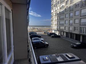 a row of cars parked in a parking lot outside a building at Studi'eau2 in Ostend