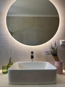 a white sink in a bathroom with a mirror at Nefeli's apartment in Vonitsa +7 photos