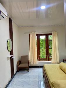 a bedroom with a bed and a chair and a window at Sekar Homestay in Bantul