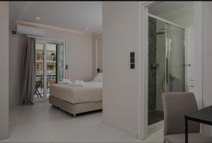 a bedroom with a bed and a walk in shower at Dimitra Suites in Pythagoreio