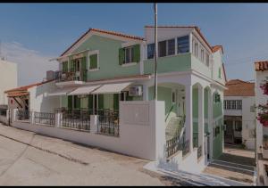 a green and white house with a balcony at Dimitra Suites in Pythagoreio +3 photos