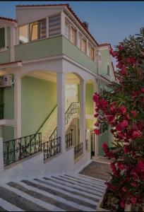 a house with stairs and flowers in front of it at Dimitra Suites in Pythagoreio