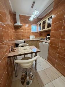 a kitchen with a table and chairs in a room at Flóra Apartmanok in Parádsasvár +82 photos