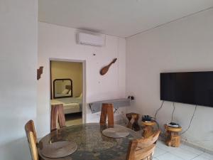 a dining room with a table and a television at Location chambres chez Zam in Mamoudzou